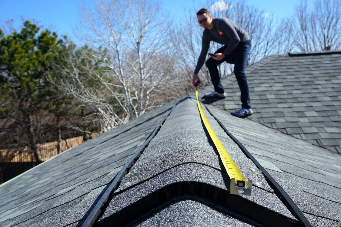 A person measuring a roof.