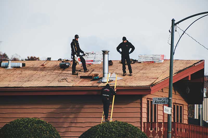 Men standing on top of a roof